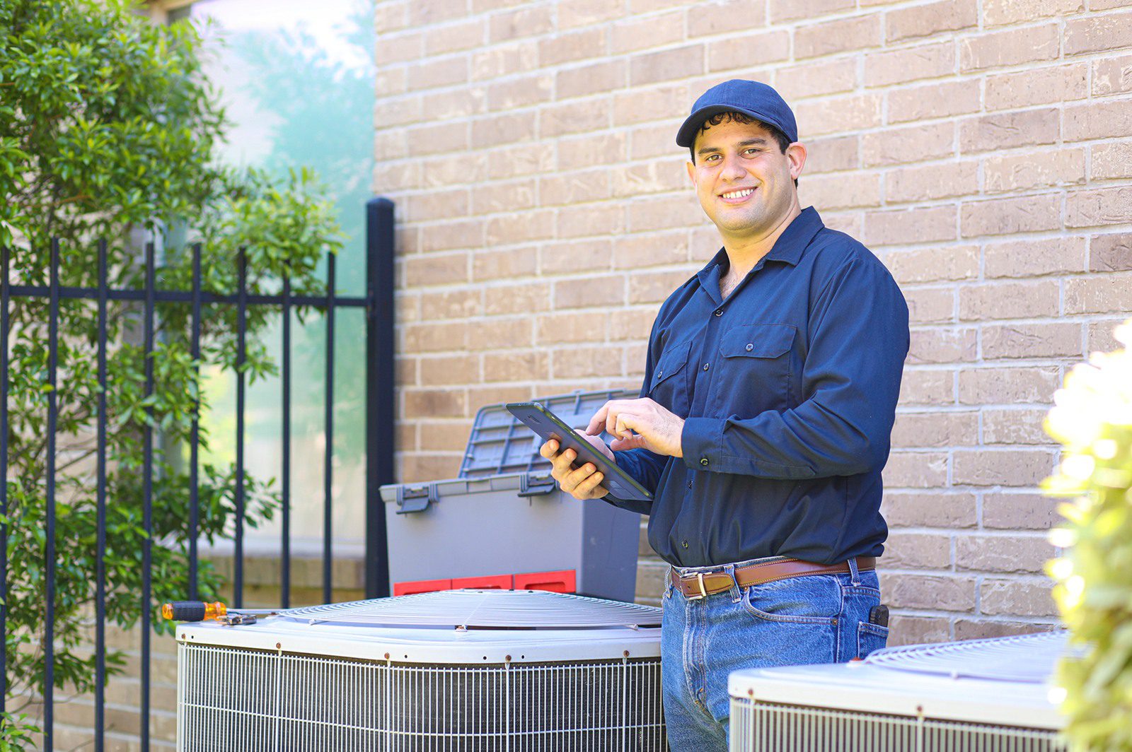 HVAC professional with tablet near units